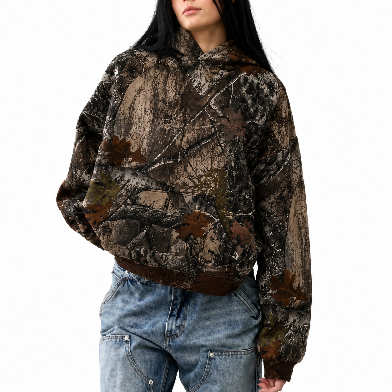 Person wearing a camouflage hoodie and jeans on a white background